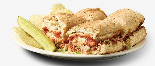 Pizza King stromboli sandwich served with chips and a pickle